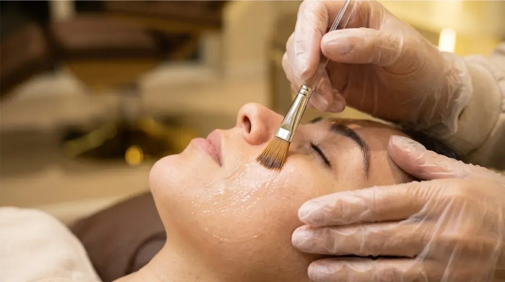 Aplicação de máscara facial rejuvenescedora com pincel na região dos olhos e testa por profissional de estética na clínica Jaque Vaz Estética e Saúde em Guarapuava PR